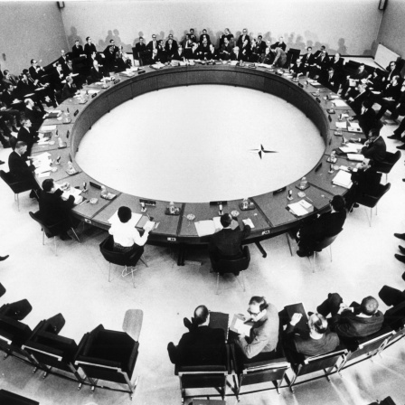 Vertreter der zwölf Nato-Mitgliedsstaaten sitzen 1949 um einen Konferenztisch.