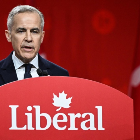 Der kanadische Premierminister Mark Carney im März 2025 in Ottawa bei einer Wahlkampfrede. Er steht an einem Rednerpult mit der Aufschrift "Liberal", dem Namen seiner Partei.
