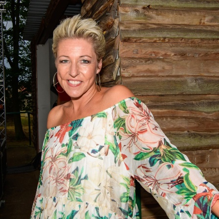 Die Schlagersängerin Alexandra Hofmann vor einer Holzwand nach einem Auftritt.
