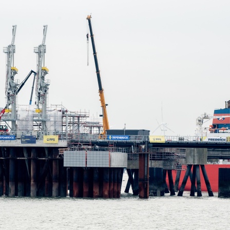 Technische Anlagen und ein Kran stehen auf dem Anleger für das LNG-Terminal in der Nordsee vor Wilhelmshaven. Der erste Anleger für Flüssigerdgas (LNG) in Deutschland ist fertiggestellt und am Dienstag eröffnet worden. In rund einem Monat soll ein beladenes Spezialschiff, eine sogenannte schwimmende Speicher- und Regasifizierungsanlage (FSRU), an dem Landungsplatz anlegen.