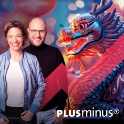 Die Plusminus Podcast Hosts Anna Planken und David Ahlf neben einer silbernen Drachenfigur