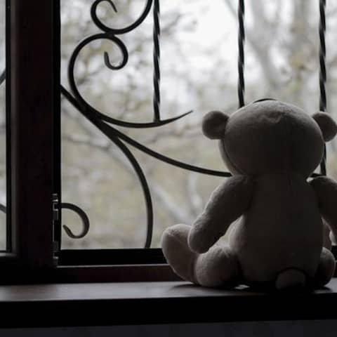 Ein Teddy steht auf einer Fensterbank