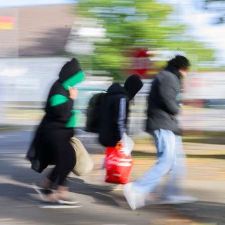 Drei Geflüchtete gehen zur Landesaufnahmebehörde Niedersachsen am Standort Braunschweig.