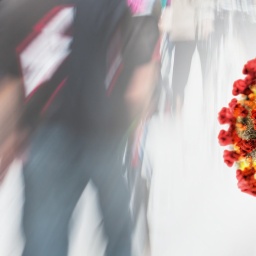 Ein Virus schwebt vor einer Menschenmenge (Fotomontage)
