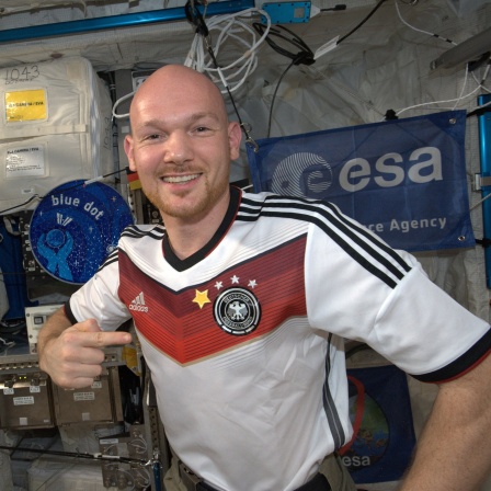 Alexander Gerst im Juli 2014 mit einem T-Shirt der deutschen Fußballnationamannschaft - ergänzt um einen 4. Stern nach der gewonnenen Weltmeisterschaft