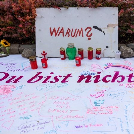 Nach der Messerattacke auf dem Solinger Stadtfest haben Menschen in der Nähe des Tatortes Nachrichten sowie Blumen und Kerzen hinterlassen.