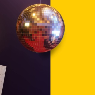 Eine Discokugel auf gelbem Hintergrund steht für die Folge &#034;Hitparaden-Kult: Disco&#034; des Podcasts &#034;5 Tage wach - Die kultigste Radio-Hitparade Deutschlands&#034;