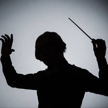 Silhouette eines Dirigenten mit Taktstock