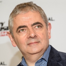 Rowan Atkinson 2018 im Hotel "The Fontenay" vor einer Wand, die den Schriftzug seines Films "Johnny English - Man lebt nur dreimal" trägt