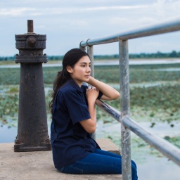 Asian girl sitting on jetty