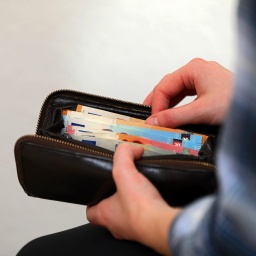 Symbolbild: Eine Frau zählt die Geldscheine ihrem Portemonnaie.