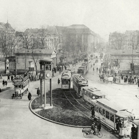 Schwarzweißfotografie vom belebten Straßen- und Fußgängerverkehr auf dem Potsdamer Platz in den 1920er-Jahren.