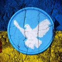 Fahne der Ukraine mit Friedenssymbol und Rissen