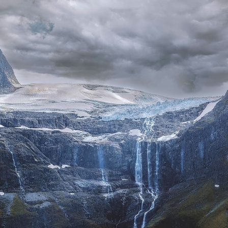 Das Wasser von einem schmelzendem Gletscher in Norwegen läuft an den Felswänden herab 