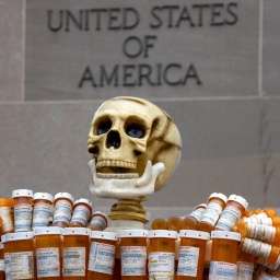 Eine Skulptur aus einem Totenschädel und leeren Medikamentendosen steht bei Protesten gegen große Pharmakonzerne vor einem US-amerikanischen Gerichtsgebäude. 