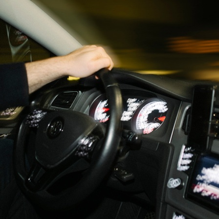 Ein Autofahrer am Steuer eines schnell fahrenden Autos.