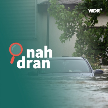 Ein Auto wird vom Hochwasser umspült. Das Wasser reicht fast bis zu den Seitenspiegeln.