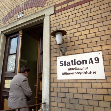 Neben der Eingangstür eines Backsteingebäudes hängt ein Schild mit der Aufrschrift "Station A9 - Abteilung für Männerpsychiatrie".