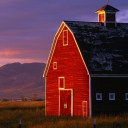 Ein rotes Farmhouse in Montana, USA, im Sonnenuntergang.