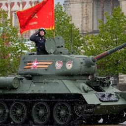 Ein legendärer sowjetischer T-34-Panzer mit roter Flagge während einer Militärparade in Moskau.
