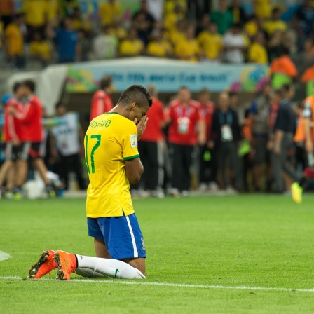 Nach der 7:1 Niederlage von Brasilien gegen Deutschlang im Halbfinale der WM 2014, knien Luiz Gustavo und David Luiz verzweifelt auf dem Rasen.