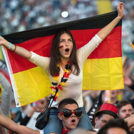 Fußballfans verfolgen in der Commerzbank-Arena beim Public-Viewing die Vorberichterstattung zur EM-Begegnung Deutschland - Polen.