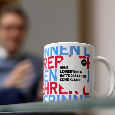 Magdeburgs Uni-Rektor Jens Strackeljan spricht während eines dpa-Interviews in seinem Büro auf dem Campus der Otto-von-Guericke-Universität Magdeburg hinter einer Tasse mit der Aufschrift «Ohne Lehrer*innen hätte das Leben keine Klasse».