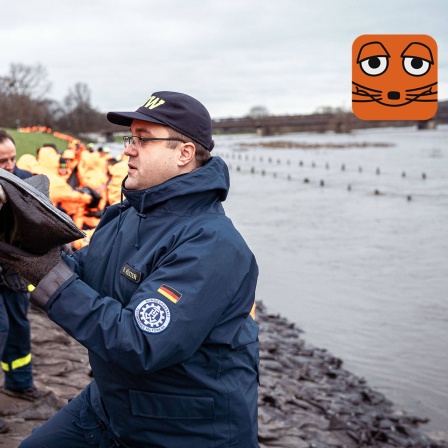 Feuerwehr und Helferinnen und Helfer sichern Deich mit Sandsäcken