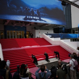 Die Presse schaut zu, wie auf den Stufen des Palais in Cannes der rote Teppich ausgerollt wird