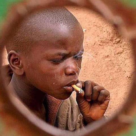 Ein Junge aus Senegal raucht eine Zigarette