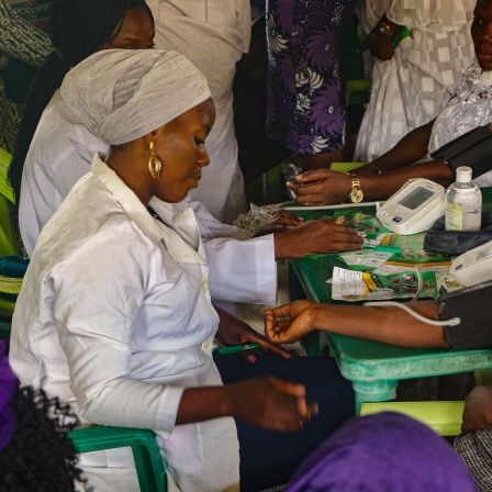 Eine Krankenschwester behandelt eine Frau während einer kostenlosen medizinischen Untersuchung anlässlich des Internationalen Tages der Frau in Lagos, Nigeria.