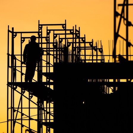 Bauarbeiter errichten bei Sonnenaufgang ein Gebäude am Kronberg