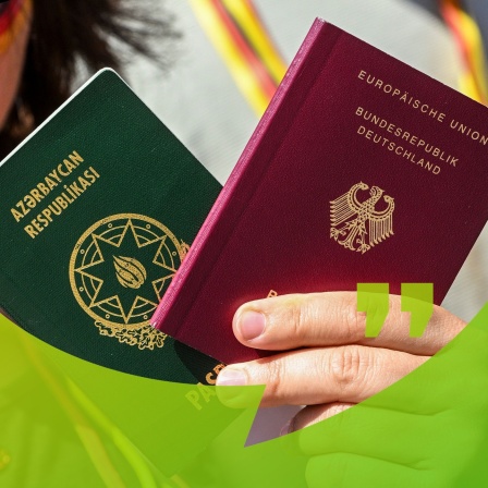 Ein Pass aus Aserbaidschan und ein deutscher Pass werden in der Hand gehalten | Bild: picture alliance/dpa | Jens Kalaene
