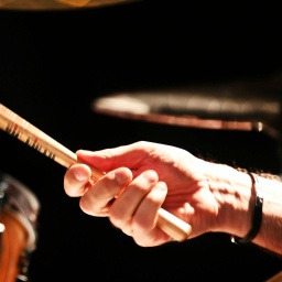 Symbolbild: Nahaufnahe einer Person, die auf einem Schlagzeug spielt.