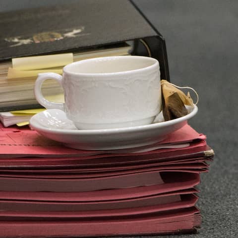 ARCHIV - Eine Teetasse steht auf einem Aktenstapel, der auf dem Boden liegt (Symbolbild)