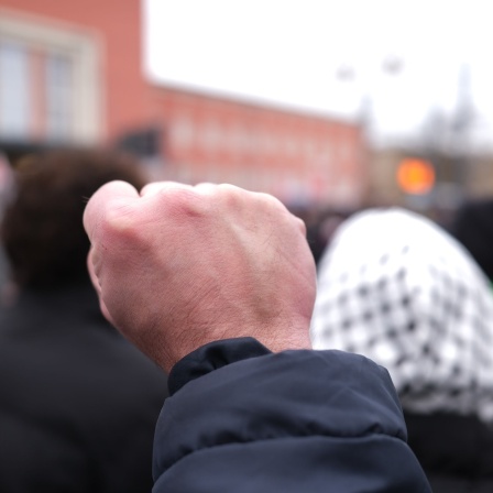 Teilnehmer einer Demonstration hebt die geballte Faust.