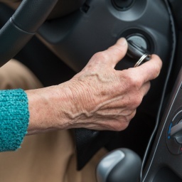 Eine Seniorin startet mit dem Zündschlüssel ihr Auto