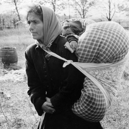 Mit wenigen Habseligkeiten und ihrem Kind auf dem Rücken erreicht diese ungarische Frau am 6. November 1956 das Flüchtlingslager Traiskirchen in Österreich. Die einsetzenden Massenverhaftungen nach dem gescheiterten Ungarn-Aufstand 1956 haben zu verstärkten Flüchtlingsströmen nach Österreich geführt.