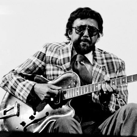 Ein Mann mit Sonnenbrille spielt auf einer E-Gitarre