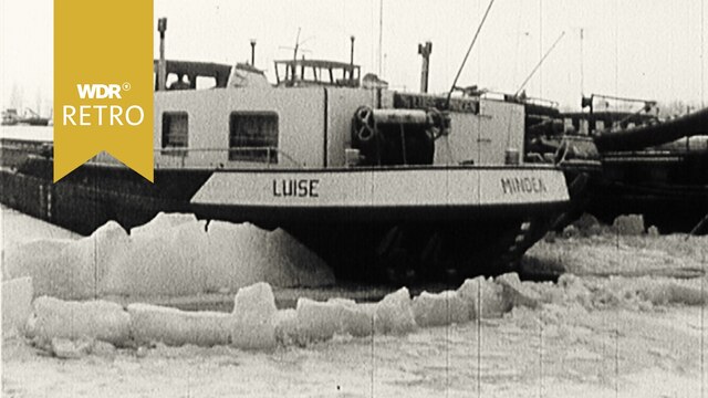 Schiff sitzt im zugefrorenen Hafen fest.