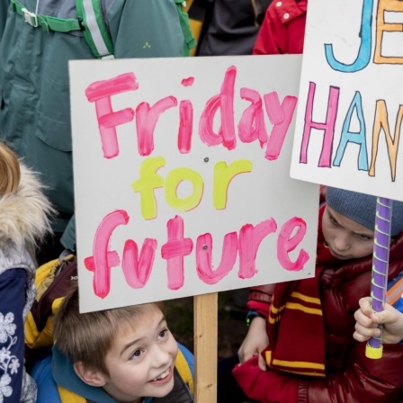 Drei junge Schulkinder zwischen sieben und acht Jahren demonstrieren am 22. März 2019 in Berlin im Rahmen der Proteste "Friday for Future". Sie halten ein Schild mit der Aufschrift "Jetzt handeln" nach oben. 
