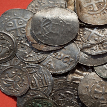 Zusammenstellung von sächsischen, ottonischen, dänischen und byzantinischen Münzen, z.T. wohl als Anhänger genutzt (durchlocht) liegen auf einem Tisch.