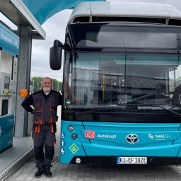 Sven Hensel, Busfahrer Autokraft steht neben einem Wasserstoffbus an der Wasserstofftankstelle in Niebüll.