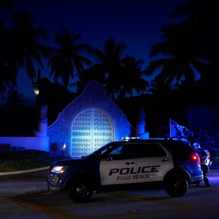 Polizisten stehen vor dem Eingang des Mar-a-Lago-Anwesens des ehemaligen Präsidenten Trump. 