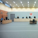 Die Beteiligten in einem Prozess gegen einen mutmaßlichen ehemaligen KZ-Wachmann stehen im Gerichtssaal in Brandenburg/Havel