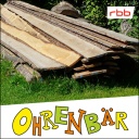Holzbretter auf einer grünen Wiese, daneben Buschwerk (Quelle: rbb/OHRENBÄR/Sonja Kessen)