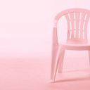 Ein Plastikstuhl mit rosa Hintergrund. 