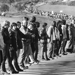 Schwarz-Weiß-Foto zeigt eine Menschenkette in der Nähe von Neu Ulm im Herbst 1983. Die Menschen protestieren gegen den NATO-Doppelbeschluss. (picture alliance I ASSOCIATED PRESS | Anonymous)