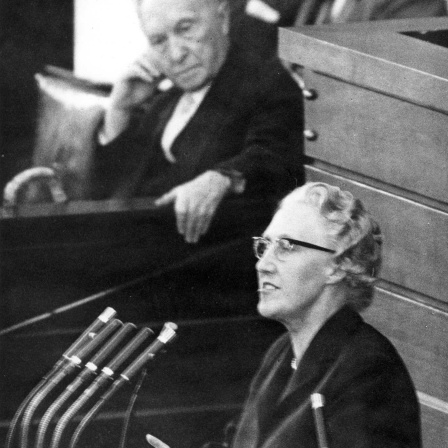 Die CSU-Abgeordnete Maria Probst am Rednerpult während einer Sitzung des Deutschen Bundestages in Bonn am 22.10.1959. Im Hintergrund Bundeskanzler Konrad Adenauer (CDU).