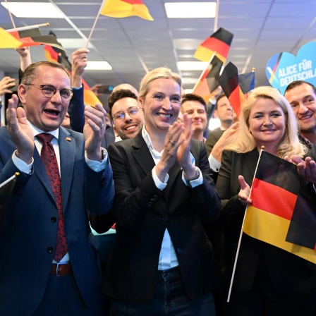 Alice Weidel, Bundesvorsitzende und Kanzlerkandidatin der AfD, auf der Wahlparty ihrer Partei - umringt von Tino Chrupalla, dem AfD-Bundesvorsitzenden sowie Kristin Brinker (AfD), an der Seite noch Björn Höcke (AfD).